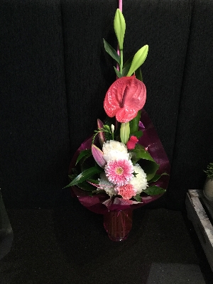 Exotic pink and white bouquet in pink glass vase